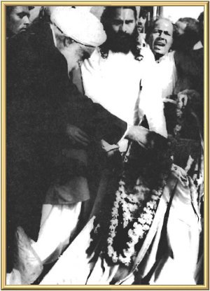 The Master gives His blessing with a garland.