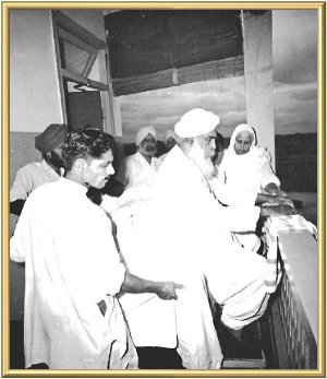 The Master sat on a high platform outside His room, so that the people could see Him.